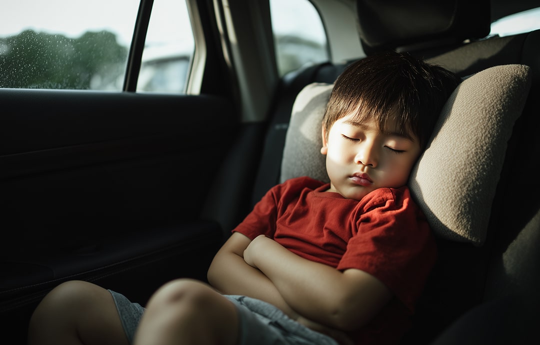 車の座席で眠る子供